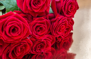 Wall Mural - Bunch of red roses on golden reflective background. Close up. Background for greeting card.