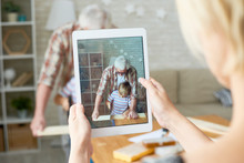 Unrecognizable Woman Taking Photo Of Grandfather And Grandson Working With Wood Together Using Digital Tablet, Image On Screen