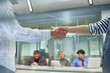 © Seventyfour - Closeup of two unrecognizable people shaking hands in office against work meeting background