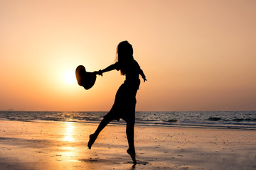 Wall Mural - Girl dancing on the beach at sunset