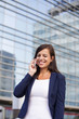 © BGStock72 - Young businesswoman talking over the mobile phone in fron of office building
