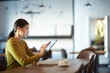 © pressmaster - Modern teenager with tablet watching online video by cup of coffe in cafe