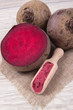 Healthy beetroot juice and fresh vegetables on wooden background.