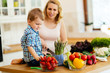 © NDABCREATIVITY - Pregnant woman preparing meal with son