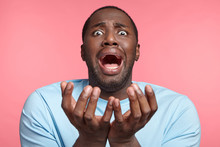 Portrait Of Stressful African American Male Has Panic Screams And Gestures In Terror, Begs Someone For Forgiveness, Doesn`t Know How To Prove His Guiltness. Black Man In Despair Poses Indoors.