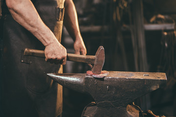 Wall Mural - Blacksmith working on metal on anvil at forge high speed detail shot