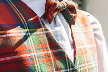 Closeup Of Matching Tartan Bowtie And Waistcoat Outdoors In The Warm Sunlight With A White Shirt Menswear Clothing