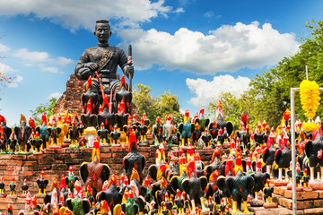 Statue of black Buddha head guarded by hundreds of roosters at Wat Thammikarat temple in Ayutthaya Province, Thailand