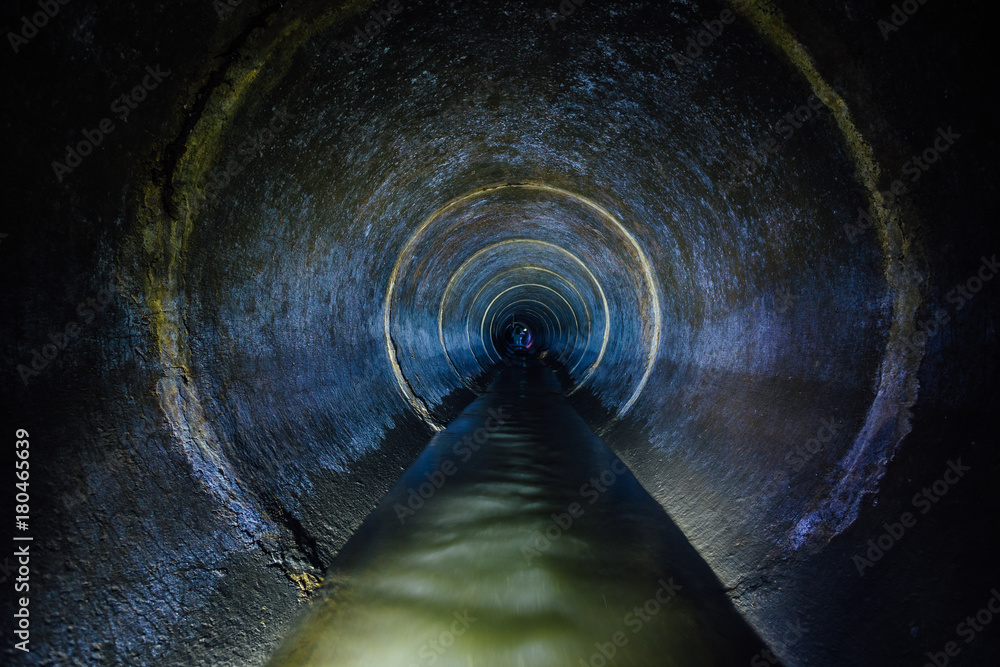 Dark underground sewer round concrete tunnel. Industrial wastewater and urban sewage flowing throw sewer pipe - obrazy, fototapety, plakaty 