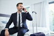 © baranq - Man making phonecall while sitting in hotel room on business trip
