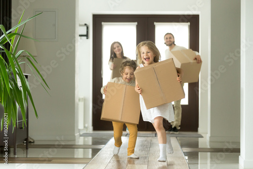 фотография  Happy family with kids bought new home, excited children funny girl and boy hold