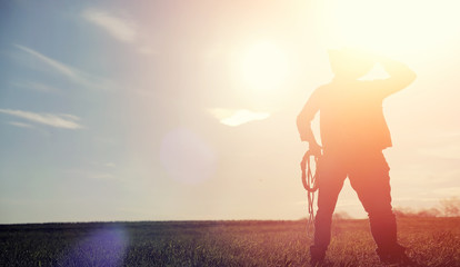 a man cowboy hat and a loso in the field. american farmer in a f