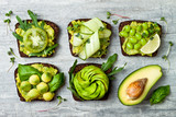 Fototapeta  - Fresh avocado toasts with different toppings. Healthy vegetarian breakfast with rye wholegrain sandwiches