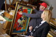 © auremar - man holding and showing a painting to auctioneer before auction