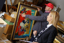 Man Holding And Showing A Painting To Auctioneer Before Auction