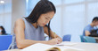 © leungchopan - Woman doing her homework in library