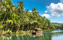 Traditional Raft Boat With Tourists On A Jungle Green River Loboc At Bohol Island Of Philippines