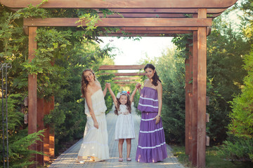 Amazing Brunette blond chestnut blue eyes sisters girls wearing stylish white purple dress enjoying vacation together spring sunny day in garden meadow on fresh grass lovely smiling