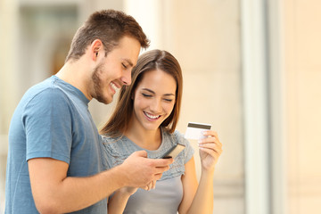 Canvas Print - Couple paying on line with credirt card on the street