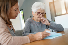 Home Assistant Helping Elderly Woman With Paper Work