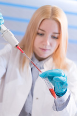 Wall Mural - Laboratory assistant in the medical laboratory control a microbiological analysis of the blood. Using a pipette and a test tube in the laboratory