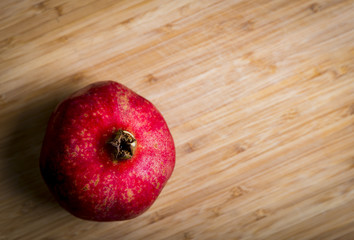 Poster - Fresh red pomegranate on the wood background, studio shot