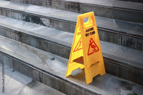 Cuadros en Lienzo Yellow caution wet floor sign at staircase of outdoor city.