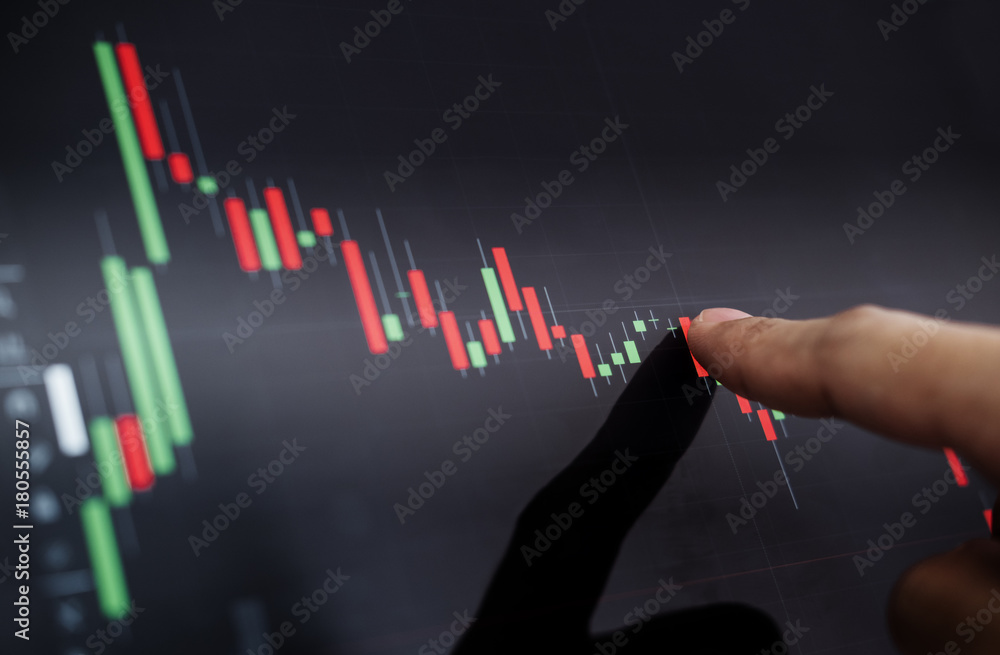 Close-up finger pointing on stock exchange chart