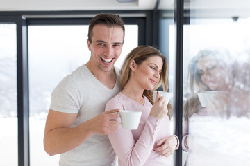 Wall Mural - young couple enjoying morning coffee by the window