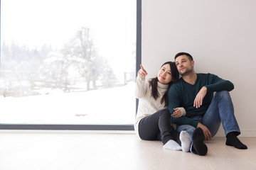 Wall Mural - multiethnic couple sitting on the floor near window at home