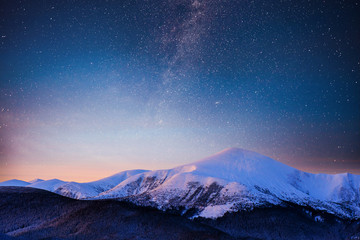 beautiful winter landscape in the carpathian mountains. vibrant night sky with stars and nebula and 