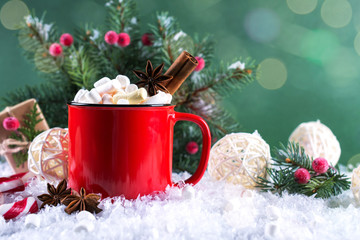 Red cup of hot spicy Christmas drink and New Year  decorations. On green background.