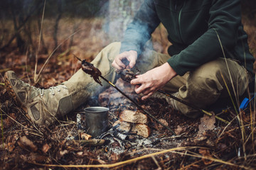 quail on the stick grilled in the fire. delicious forest picnic. bushcraft concept