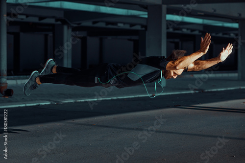 Fotografía Young man doing push ups with jumps in the urban environment