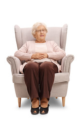 Wall Mural - Elderly woman sitting in an armchair and looking at the camera