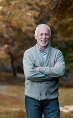 Elderly man smiling outdoors in nature 