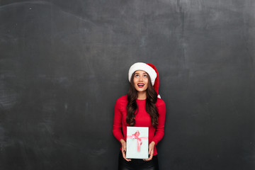 Canvas Print - Happy brunette woman in red blouse and christmas hat