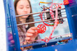 Girl schoolgirl with a 3D printer