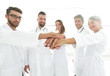© ASDF - Doctors and nurses in a medical team stacking hands