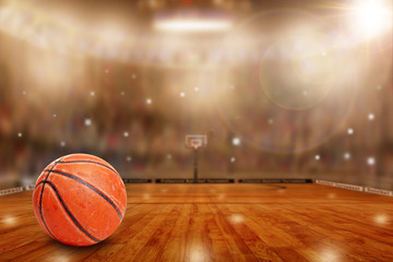 Wall Mural - Fictitious basketball arena with ball on court and copy space. Camera flashes and lens flare special lighting effect on defocused background.