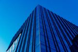Modern glass skycrapers background with sky and clouds reflection of city