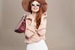 © SHOTPRIME STUDIO - woman with glasses, hat and with a bag on a light background