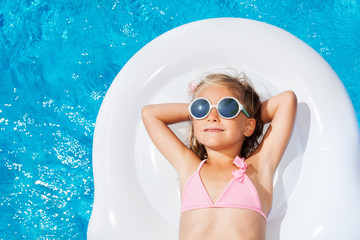 Wall Mural - Cute girl on inflatable mattress in swimming pool