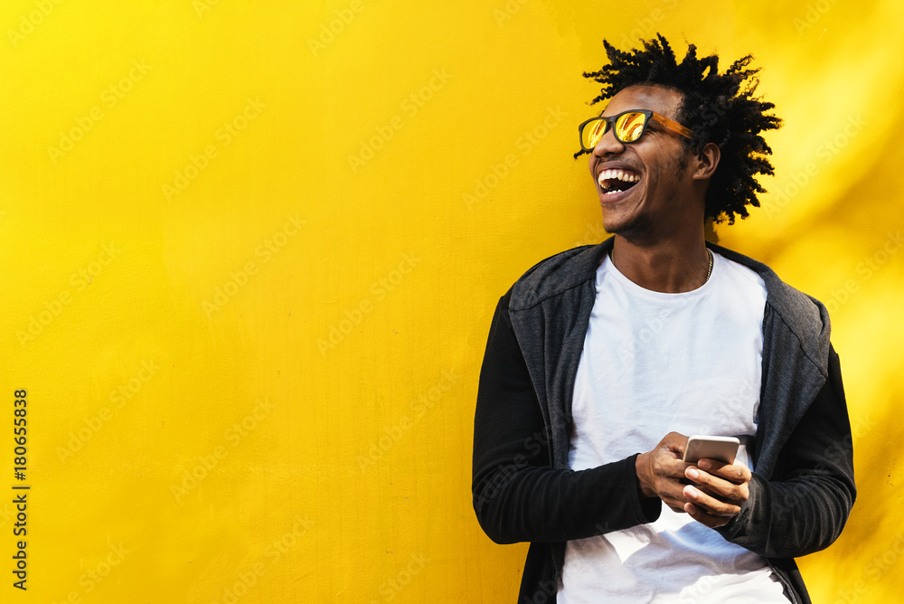 Portrait of handsome afro man using his mobile. - obrazy, fototapety, plakaty 
