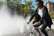 © santypan - Handsome afro man riding a bike.