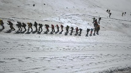 Wall Mural - aerial view hiking group in mountain on snow trail. extreme hiking in mountain