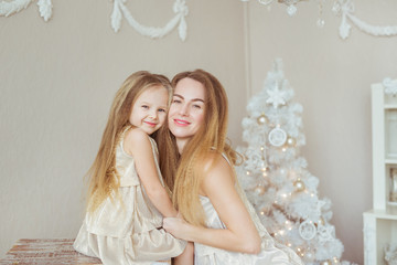 Portrait of young smiling mother and daughter in Christmas