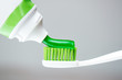 Green toothpaste on the brush closeup