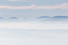 Fog Filling A Valley, With Layers Of Mountains And Hills And Various Shades Of Blue