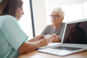 Nurse giving prescription to elderly woman